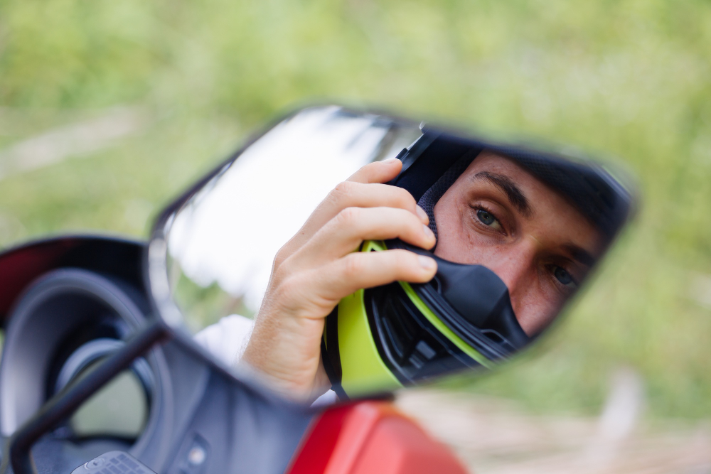 Motard qui se regarde dans le rétroviseur de sa moto