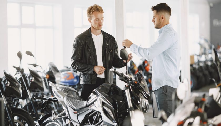 Homme donnant les clefs d'une moto à un acheteur
