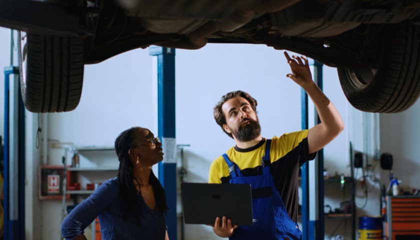 mécanicien et cliente sous une voiture