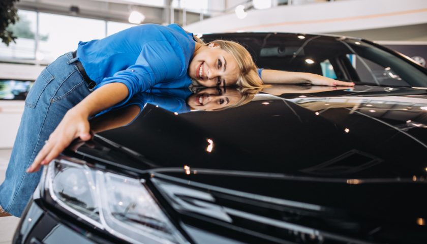 une femme enlaçant sa voiture