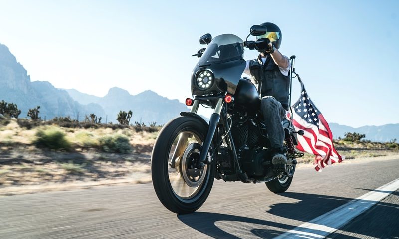 un homme sur une moto avec le drapeau des etats-unis