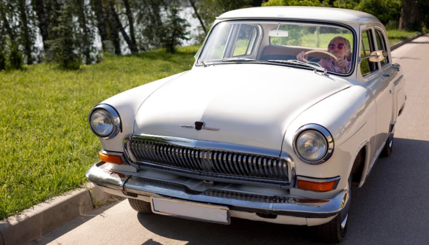 une dame se balladant en voiture de collection