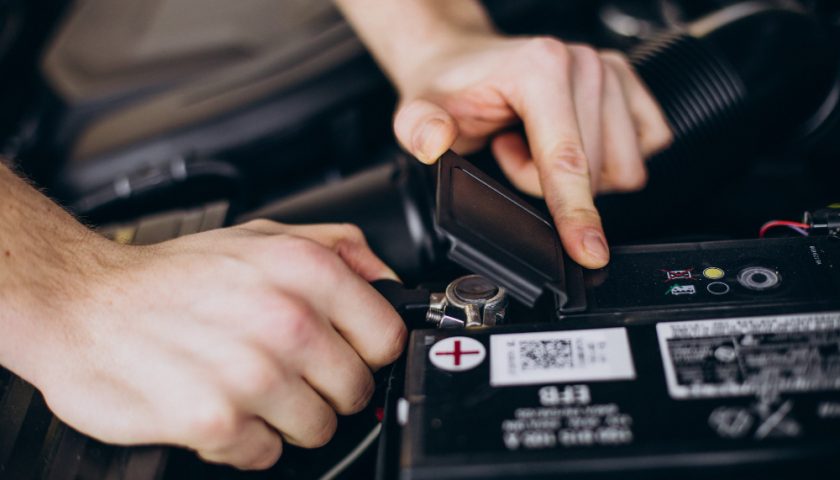 un homme touchant une batterie de voiture