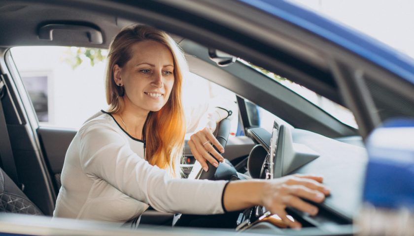 une femme cherchant son assurance auto dans sa boite à gant