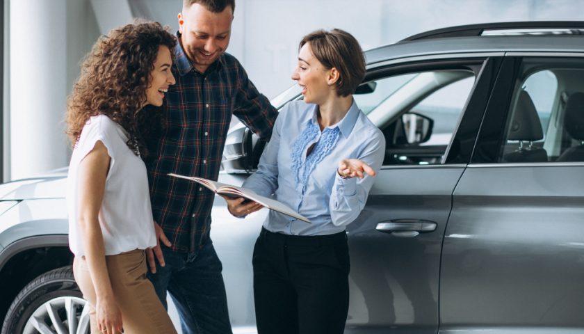 un couple parlant d'assurance auto à une personne travaillant dans l'assurance