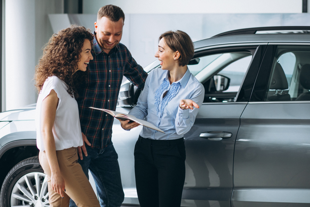 un couple parlant d'assurance auto à une personne travaillant dans l'assurance